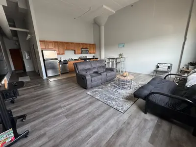 a living room with a couch and chairs and a kitchen at Spacious Condo Minutes to Cedar Point in Sandusky
