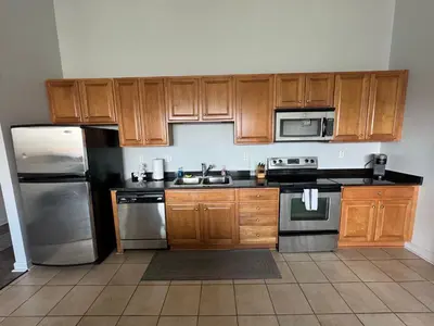 a kitchen with wooden cabinets and stainless steel appliances at Spacious Condo Minutes to Cedar Point in Sandusky