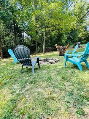 three chairs sitting in the grass in a yard at Creekside Haven Tiny Home