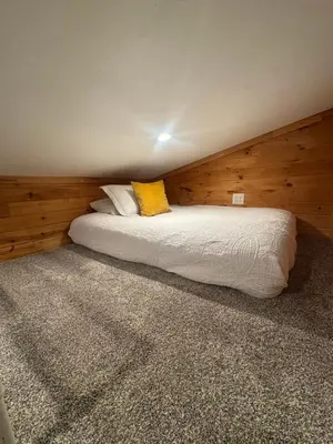 a bedroom with two beds with wooden walls at Creekside Haven Tiny Home