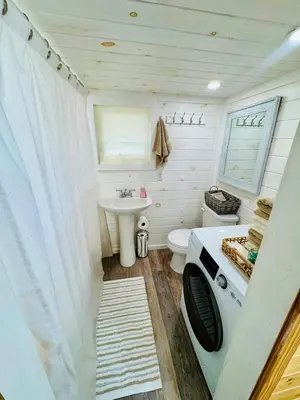 a tiny bathroom with a sink and a toilet at Creekside Haven Tiny Home