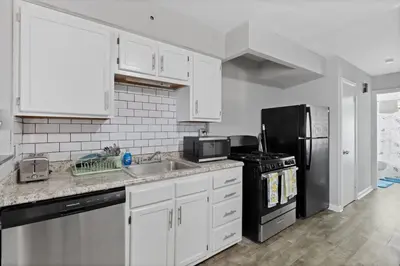 a kitchen with white cabinets and a black refrigerator at Luxury room in Cincinnati in Cincinnati
