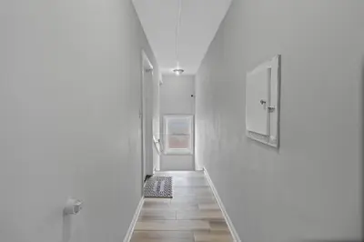 a hallway with white walls and a wooden floor at Luxury room in Cincinnati in Cincinnati