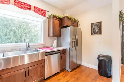 a kitchen with a stainless steel refrigerator and a window at White Fern