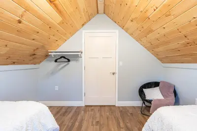 a bedroom with white walls and a wooden ceiling at White Fern