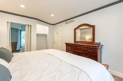 a bedroom with a bed and a dresser and a mirror at White Fern
