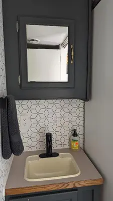a bathroom sink with a mirror on a counter at Whispering Pines Retreat (RV) in Glenmont