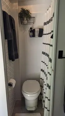 a bathroom with a toilet and a shower curtain at Whispering Pines Retreat (RV) in Glenmont
