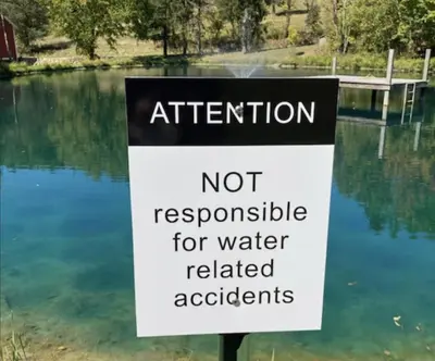 a sign that reads not responsible for water related accidents at Whispering Pines Retreat (RV) in Glenmont