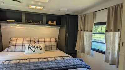 a bedroom with a bed with a pillow on it at Whispering Pines Retreat (RV) in Glenmont