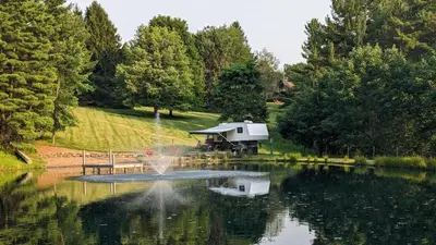 a pond with a fountain in the middle of it at Whispering Pines Retreat (RV) in Glenmont