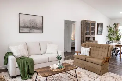 a living room with a couch and a table at Creek View Cottage