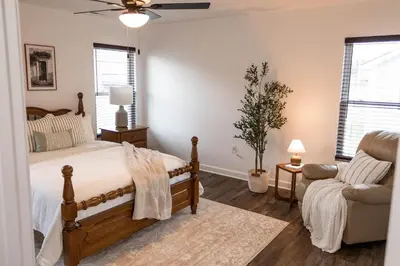 a bedroom with a bed and a couch and a chair at Creek View Cottage
