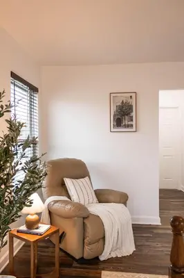 a living room with a couch and a table at Creek View Cottage