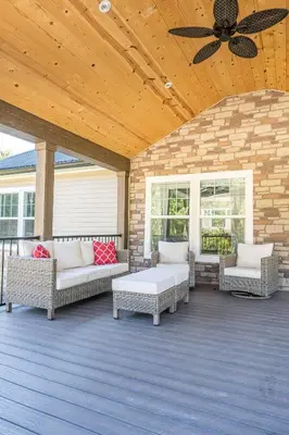 a screened porch with couches and a ceiling fan at Wildcat Lodge, Wallingford KY in Wallingford