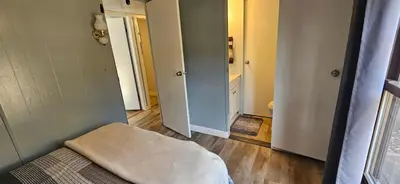 a small room with a bed and a bathroom at High Tide Escape