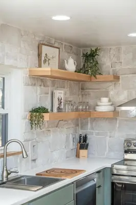 a kitchen with a stone wall with wooden shelves at Tranquility Cove in Dover