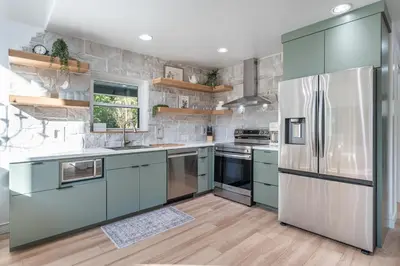 a kitchen with blue cabinets and a stainless steel refrigerator at Tranquility Cove in Dover