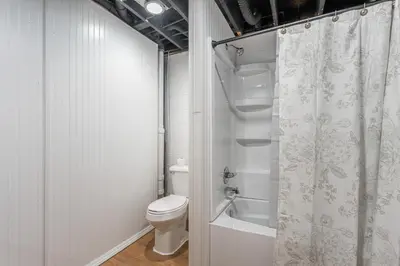 a bathroom with a toilet and a shower curtain at Tranquility Cove in Dover