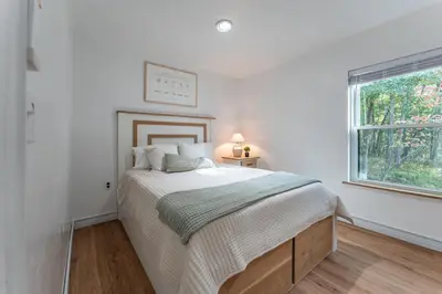 a white bedroom with a bed and a window at Tranquility Cove in Dover