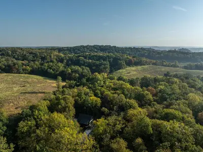 an aerial view of a forest with a house in the middle at Tranquility Cove in Dover