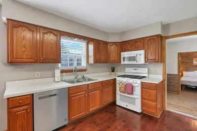 a kitchen with wooden cabinets and white appliances at Quiet Ranch Retreat for Work Crews & Families Johnstown OH