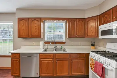 a kitchen with wooden cabinets and a sink at Quiet Ranch Retreat for Work Crews & Families Johnstown OH