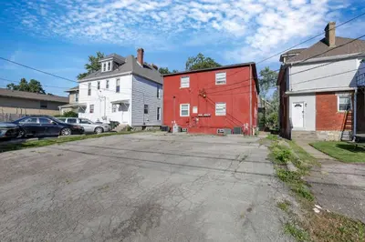 an empty street with a red barn and a white house at Spacious 5-Bedroom Retreat in Central Columbus Perfect for Groups in Columbus