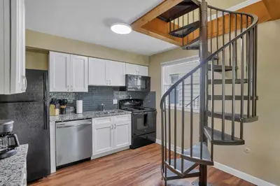 a kitchen with a spiral staircase leading up to a kitchen at Spacious 5-Bedroom Retreat in Central Columbus Perfect for Groups in Columbus