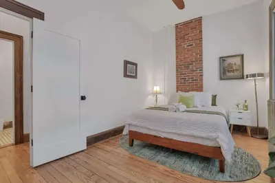 a bedroom with a bed and a brick wall at Spacious Historic 8-Bedroom Manor in Short North - Perfect for Large Groups in Columbus