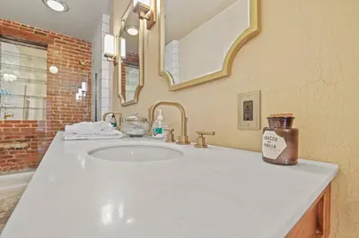 a bathroom with a white sink and a mirror at Spacious Historic 8-Bedroom Manor in Short North - Perfect for Large Groups in Columbus