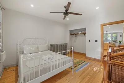 a white crib in a room with a ceiling fan at Spacious Historic 8-Bedroom Manor in Short North - Perfect for Large Groups in Columbus