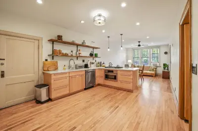 a large kitchen with wooden cabinets and a hard wood floor at Spacious Historic 8-Bedroom Manor in Short North - Perfect for Large Groups in Columbus
