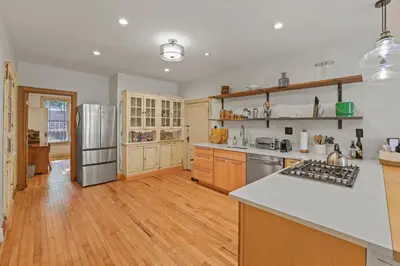 a large kitchen with wooden floors and stainless steel appliances at Spacious Historic 8-Bedroom Manor in Short North - Perfect for Large Groups in Columbus