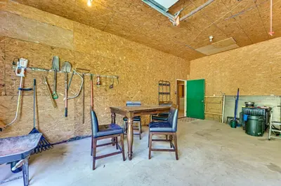 a room with a wooden table with chairs and hockey equipment at Ohio Hunters Cabin with Pond Access Pets Welcome!