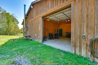 a wooden barn with a patio and a table at Ohio Hunters Cabin with Pond Access Pets Welcome!