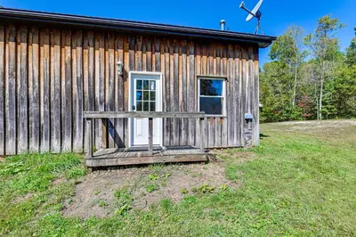 a wooden cabin with a porch and a door at Ohio Hunters Cabin with Pond Access Pets Welcome!