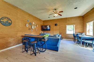 a living room with a blue couch and a table at Ohio Hunters Cabin with Pond Access Pets Welcome!