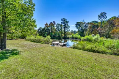a park with a lake and trees and a grass field at Ohio Hunters Cabin with Pond Access Pets Welcome!
