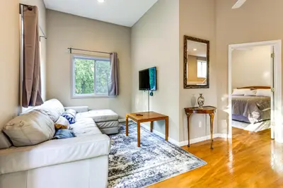 a living room with a white couch and a mirror at Large Yard with Pond Family Retreat in New Albany! in New Albany