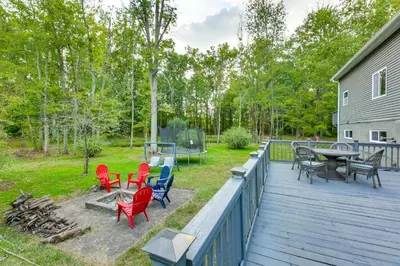a deck with chairs and tables and a table at Large Yard with Pond Family Retreat in New Albany! in New Albany