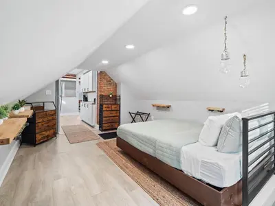 a bedroom with a large bed and a staircase at Unique BOHO Ohio City Loft Apt in Cleveland