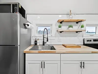 a kitchen with a sink and a refrigerator at Unique BOHO Ohio City Loft Apt in Cleveland