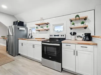 a kitchen with white cabinets and a black refrigerator at Unique BOHO Ohio City Loft Apt in Cleveland