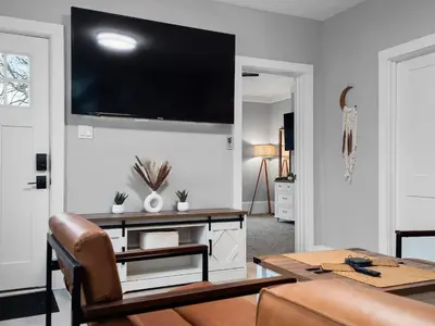 a living room with a table and a television on the wall at Amazing Boho Oasis Apartment in Ohio City in Cleveland