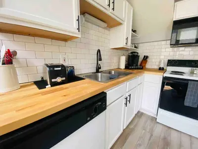 a kitchen with white cabinets and a sink at Cozy Downtown Modern Condo in the Heart of it all in Cleveland