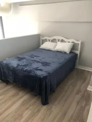 a bedroom with a bed with a blue blanket on it at Cozy Downtown Modern Condo in the Heart of it all in Cleveland