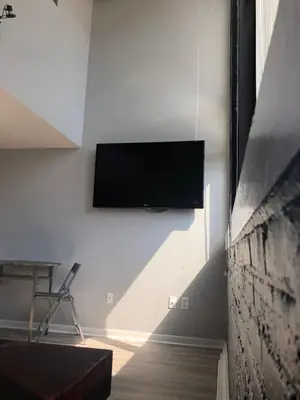a living room with a tv on a wall at Cozy Downtown Modern Condo in the Heart of it all in Cleveland