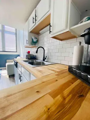 a kitchen with white cabinets and a wooden counter top at Cozy Downtown Modern Condo in the Heart of it all in Cleveland