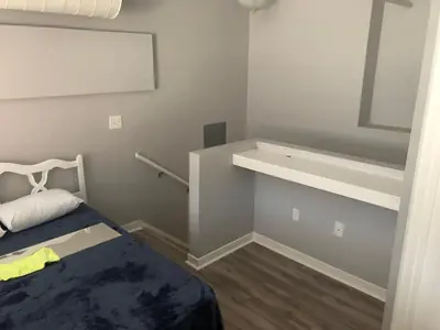 a small room with a bed and a white shelf at Cozy Downtown Modern Condo in the Heart of it all in Cleveland